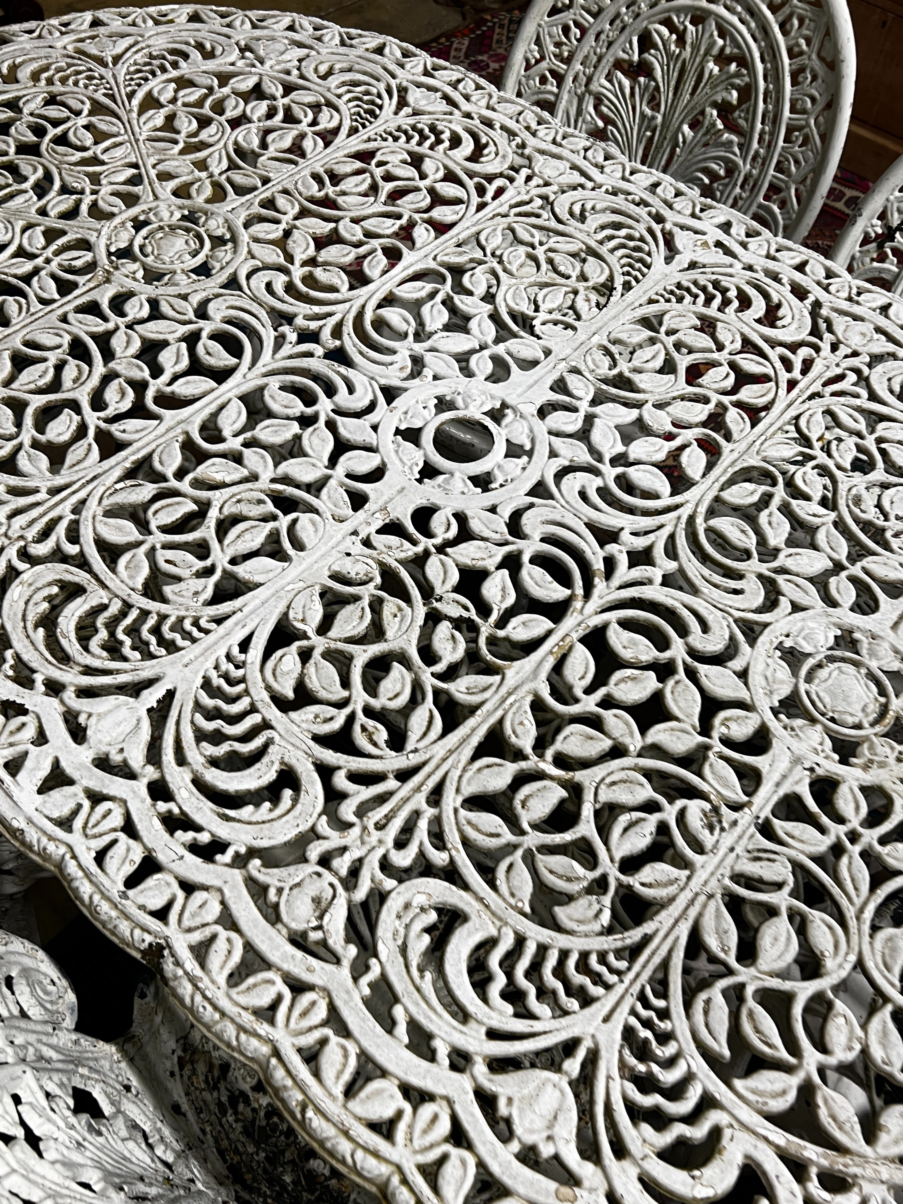 A Victorian style cast aluminium garden table, width 160cm, depth 90cm, height 67cm and six cast iron garden chairs